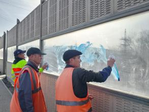 Шумозащитные экраны вокзального путепровода зачищают от граффити второй раз за несколько дней