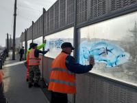 Шумозащитные экраны вокзального путепровода зачищают от граффити второй раз за несколько дней