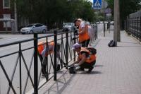 В Астрахани красят леерное ограждение и бордюры вдоль улиц